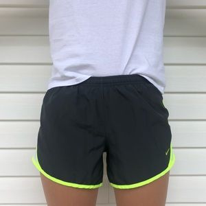 Gray Nike running shorts with neon green strip